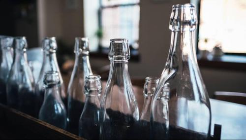 How does the gravelly texture of a glass bottle come about?